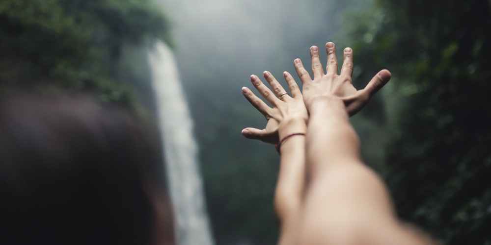 Cheerful couple enjoying river bath by waterfall