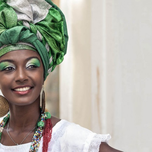 Baiana, Brazilian woman of African descent, smiling, wearing traditional attire in Pelourinho, Salvador, Bahia, Brazil.