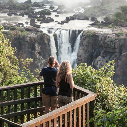 Iguacu Falls, Brazil - November 3, 2014: Tourists are enjoying the view at Iguazu Falls at sunset. The photo is taken on the Brazil side of the falls.